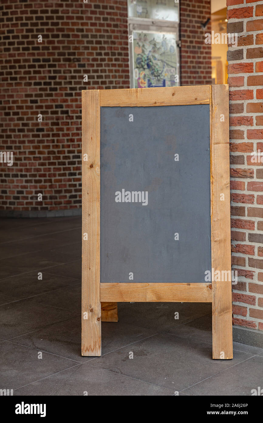 Modello di menu, lavagna a fogli mobili vuota con telaio in legno all'esterno su un marciapiede, spazio di copia Foto Stock