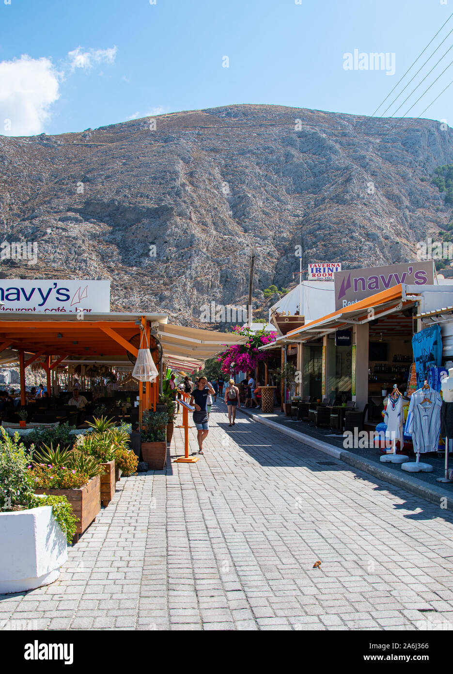 Kamari, Grecia - 14 Luglio 2019: i turisti e gli amanti dello shopping passeggiare tra i negozi e i ristoranti lungo la strada lungomare Foto Stock