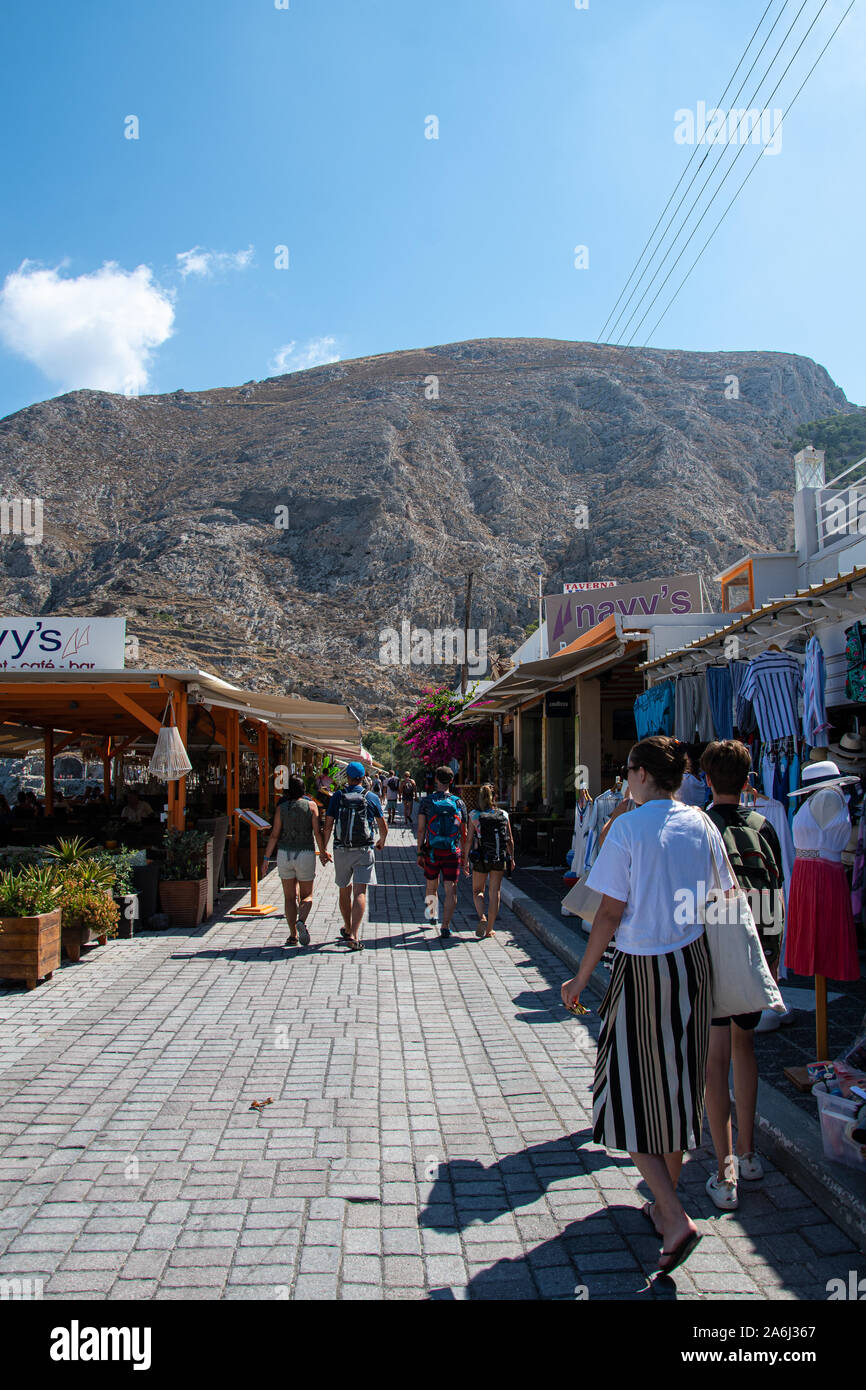 Kamari, Grecia - 14 Luglio 2019: i turisti e gli amanti dello shopping passeggiare tra i negozi e i ristoranti lungo la strada lungomare Foto Stock