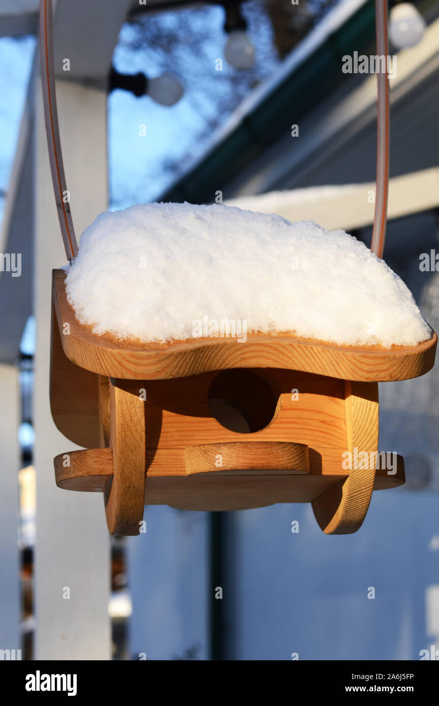 In casa legno Bird Feeder con la neve sul tetto di un inverno freddo giorno di sole Foto Stock