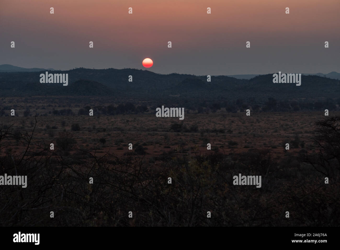 Romantico tramonto nella bussola della savana del Kalahari, Namibia, Africa. Deserto paesaggio al crepuscolo. Foto Stock