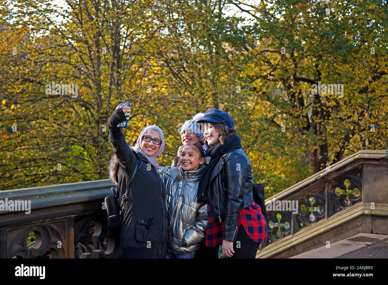 Le ragazze prendendo selfie, i giardini di Princes Street East, con colore di autunno Edimburgo, Scozia, Regno Unito. Foto Stock