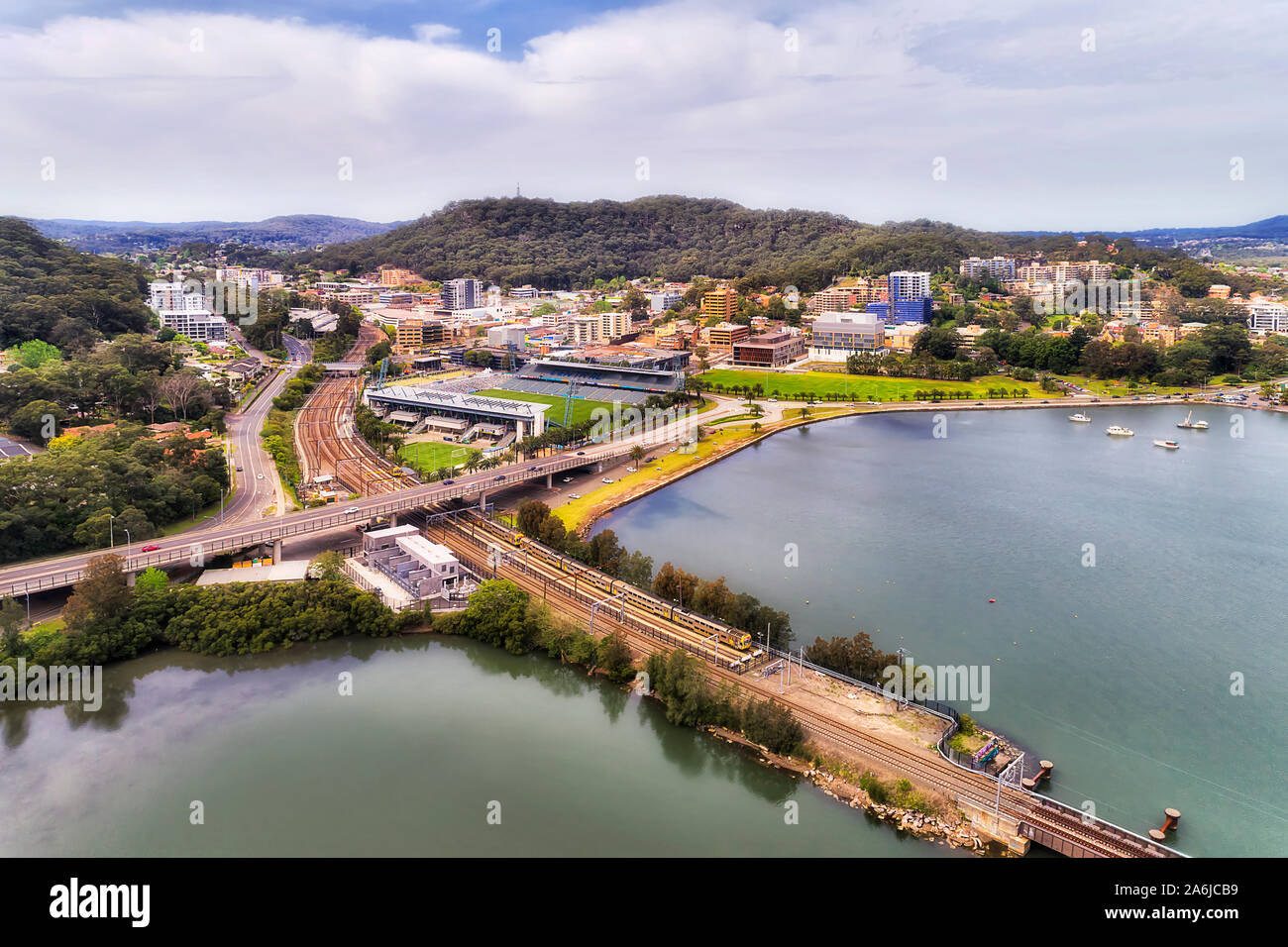 Central Coast Città Gosford presso l'intersezione della costa centrale autostrada e ferrovia fra gamme di collina su coste di Brisbane water bay - Veduta aerea Foto Stock