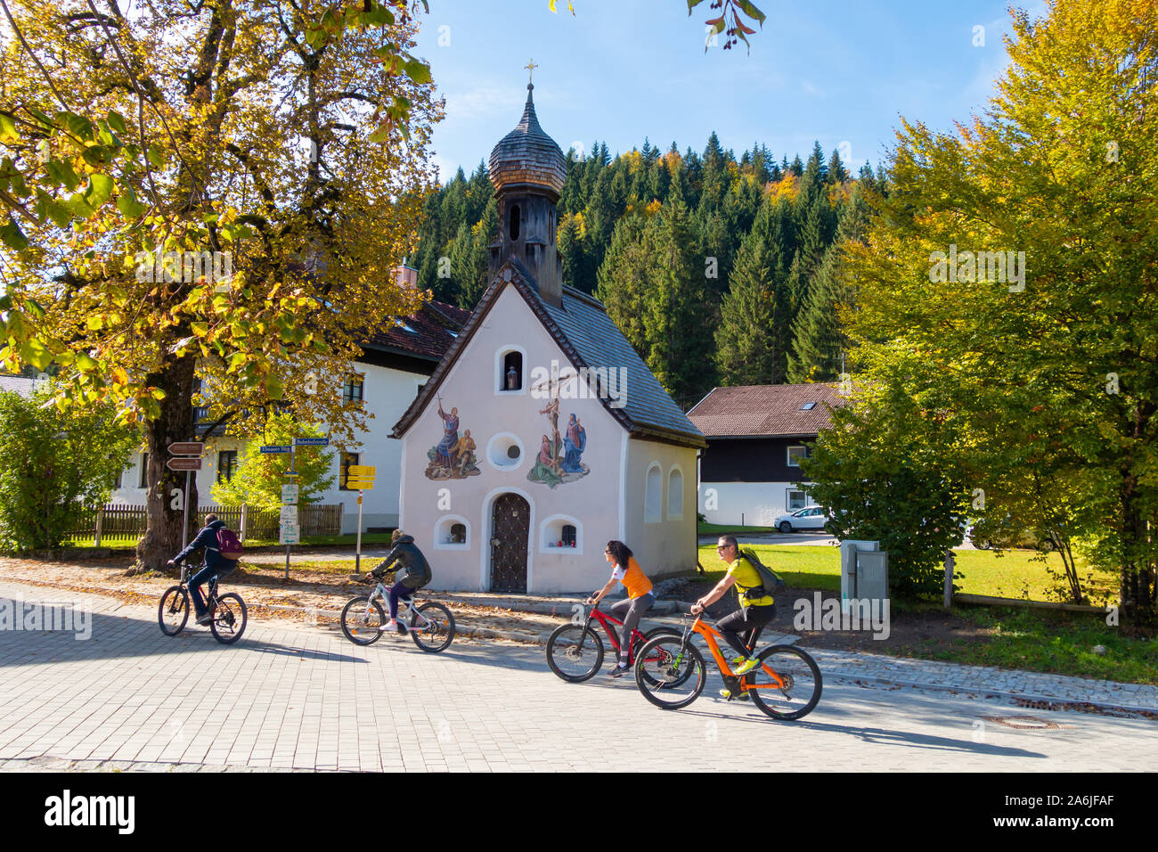 I ciclisti passano la cappella in Klais, comune di Kruen nel distretto di Garmisch-Partenkirchen in Alta Baviera. Foto Stock