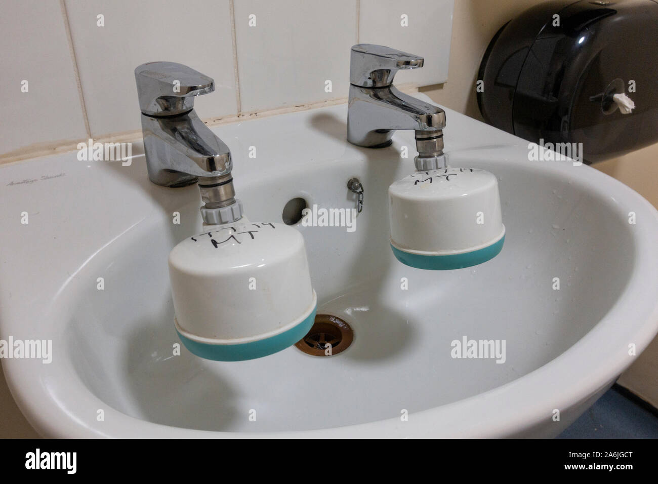 Una coppia di rubinetti in un ospedale del Regno Unito dotati di filtri speciali per legionella e controllo batterica. Foto Stock