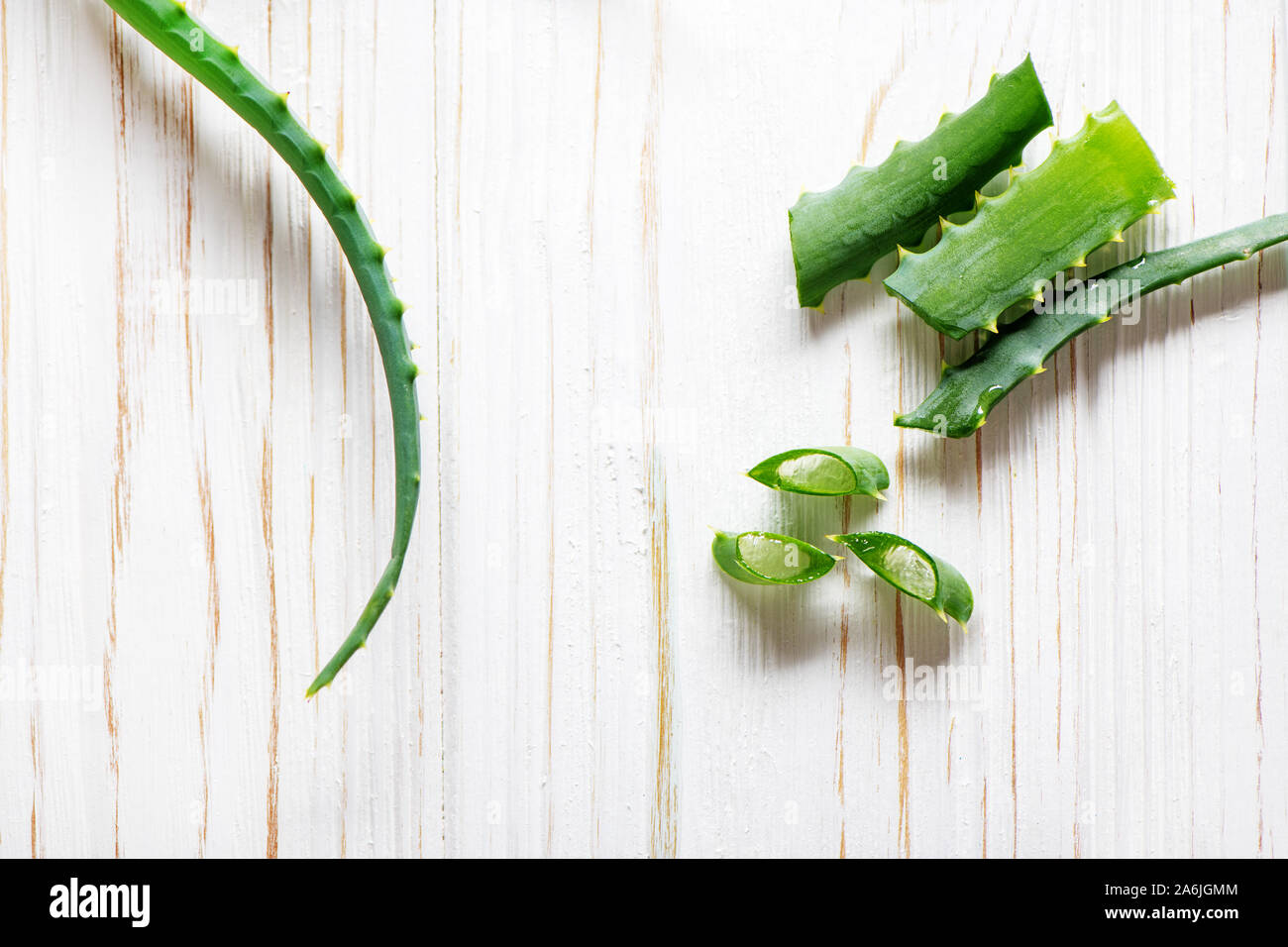 Aloe Vera le fette su un bianco sullo sfondo di legno. Lay piatto. Foto Stock