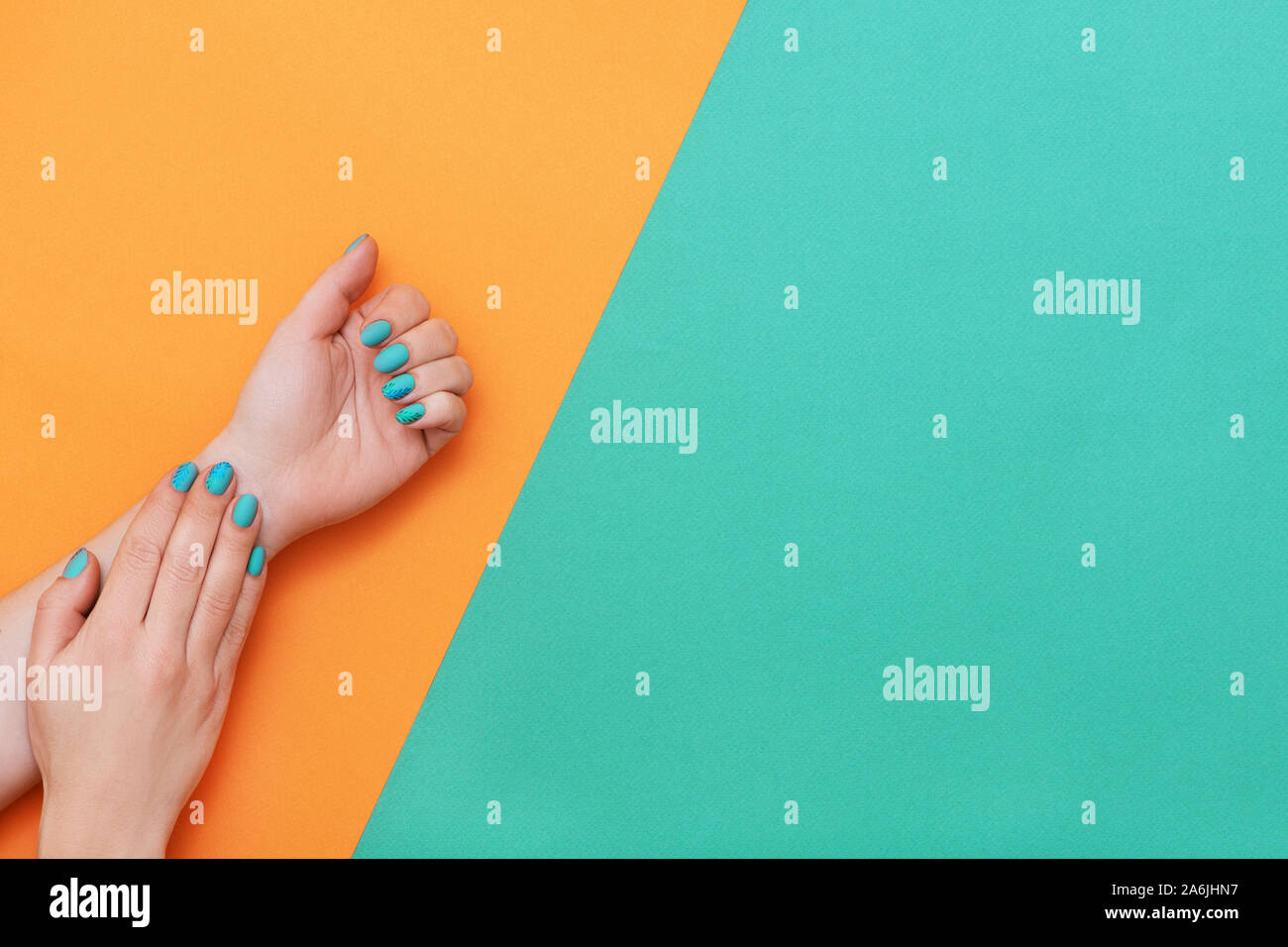 Manicure perfetta con trendy Nail art su Orange e 'turqoise' sfondo con copia spazio. Foto Stock