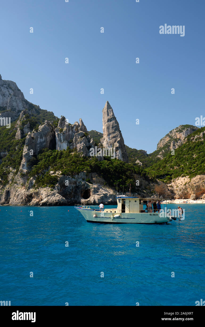 Una barca turistica a Cala Goloritzè sul Golfo di Orosei costa carsica nel Parco Nazionale del Gennargentu Ogliastra Sardegna Italia Europa Foto Stock