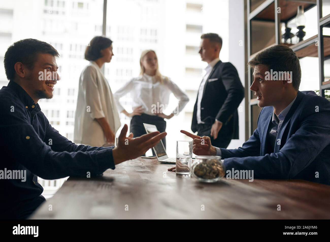 Allegro due uomini in eleganti abiti formale avente un piano astuto, uomo bello rivolto al suo collega, insegnando a lui di run business Foto Stock