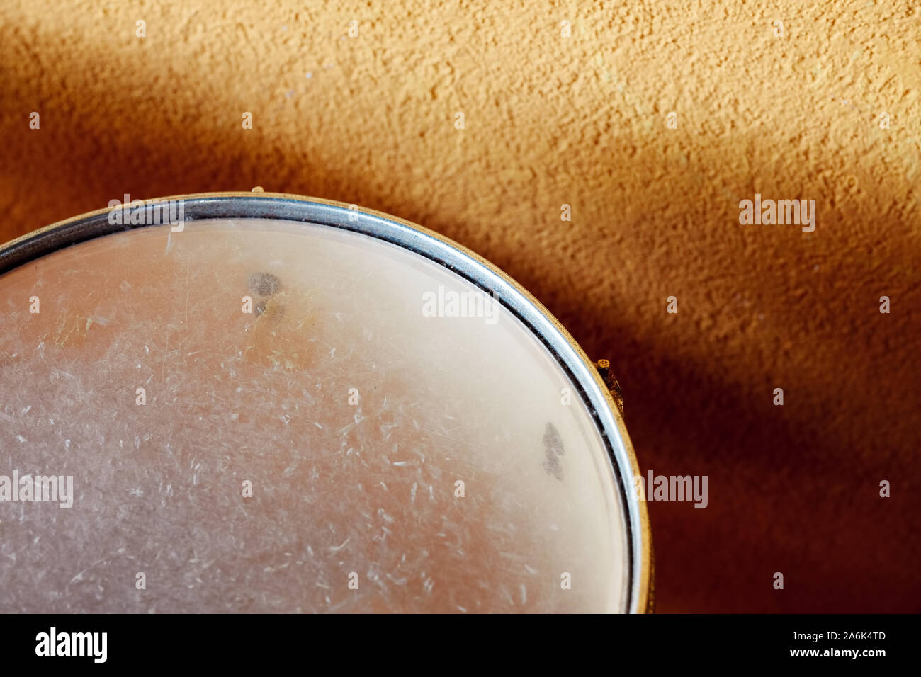 Close up tettuccio di dettaglio di un tamburo rullante allineata ad una parete gialla con spazio di copia Foto Stock