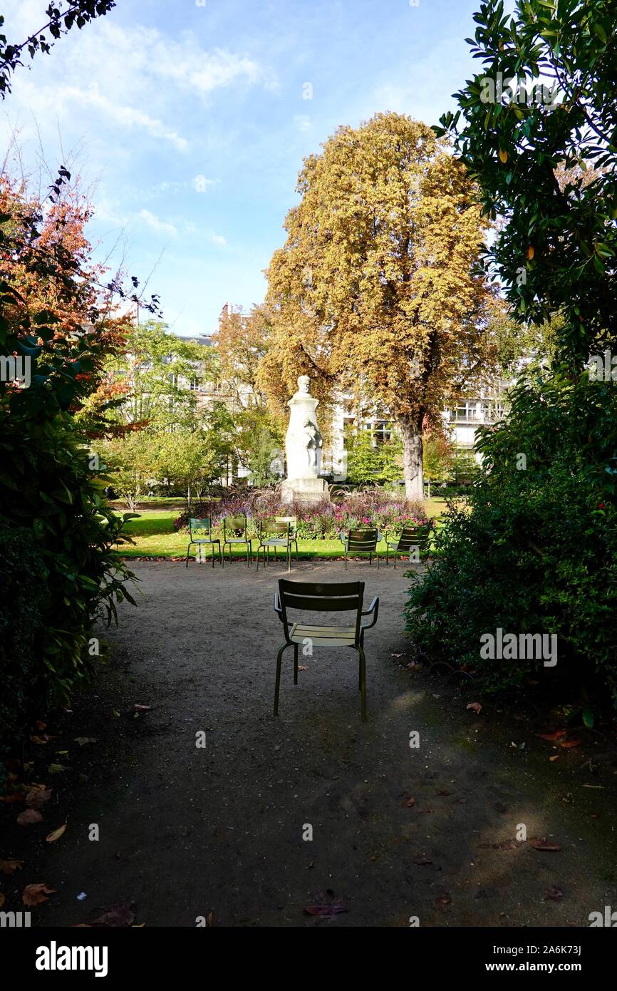 Sedie verde situato attorno ad una zona soleggiata, con una sedia nelle ombre. In autunno i Giardini di Lussemburgo, ottobre a Parigi, Francia Foto Stock