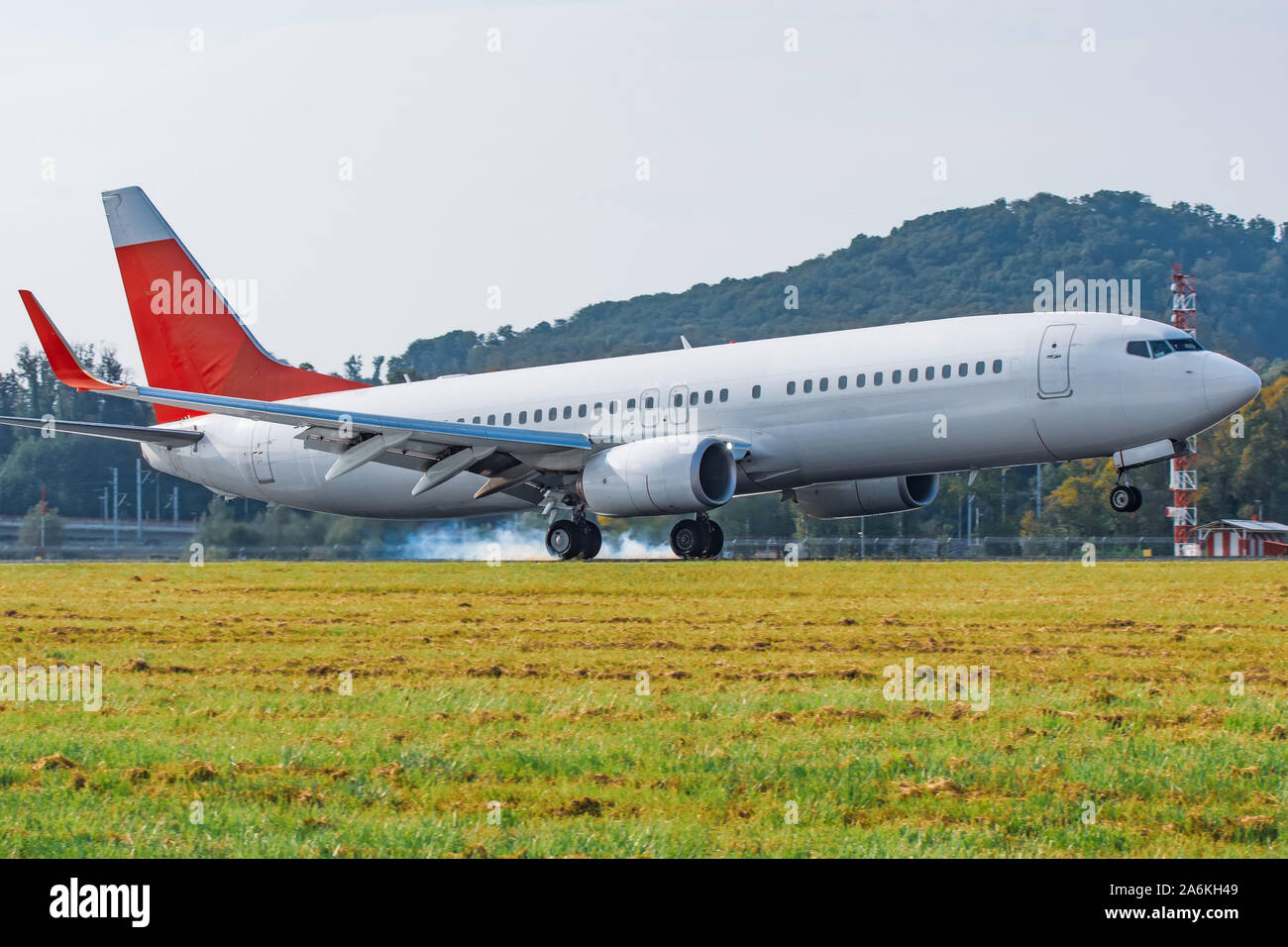 Atterraggio aereo sulla pista vista laterale touchdown con fumo di pneumatici Foto Stock
