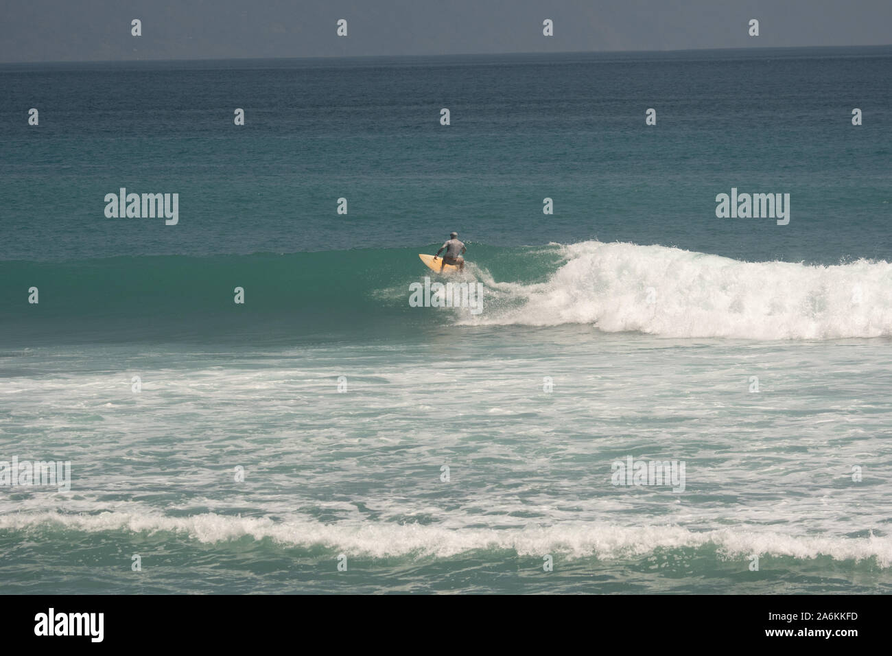 Un surfista cattura un'onda su una spiaggia in Costa Rica Foto Stock