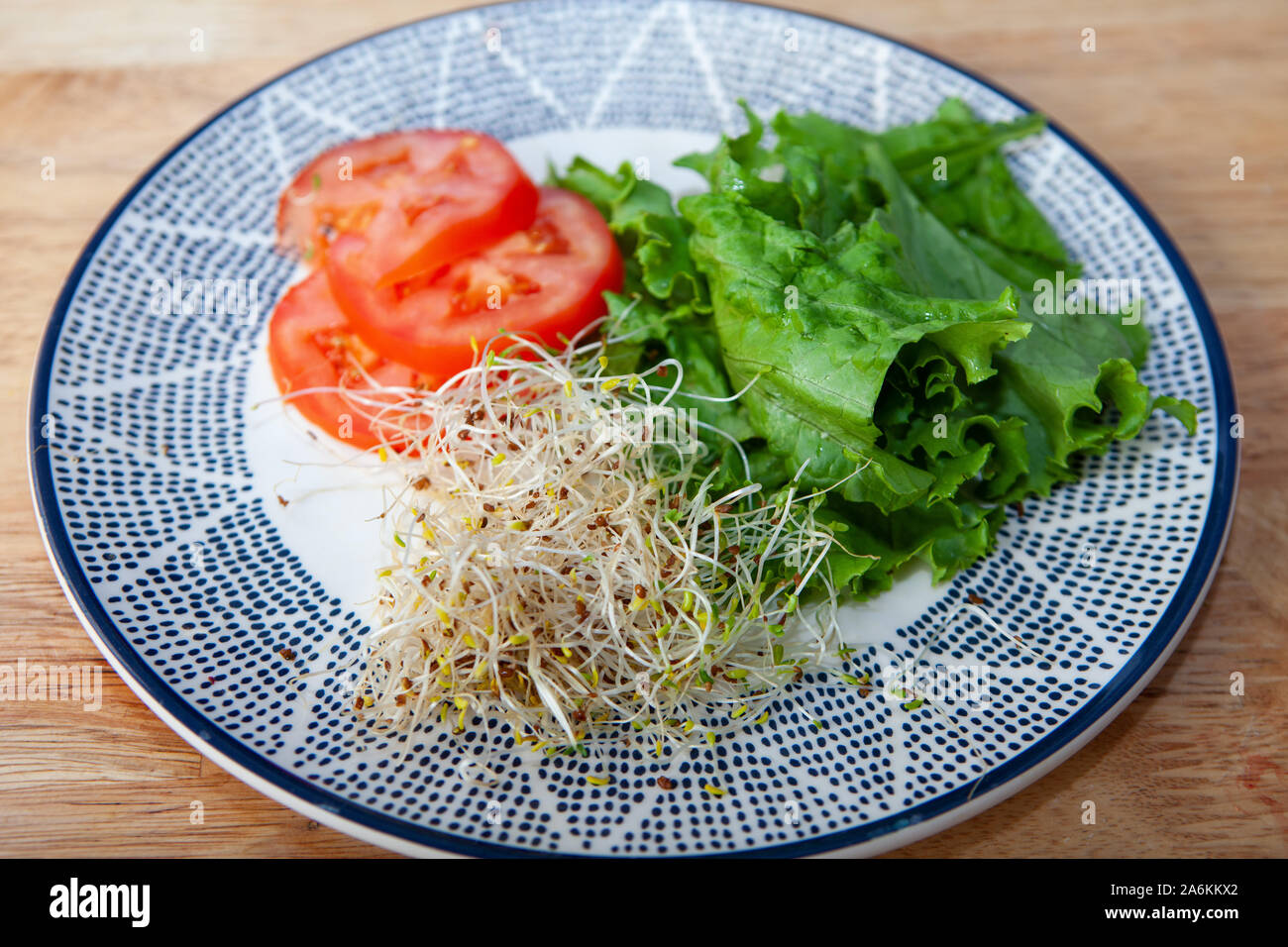Una piastra con tomatoe, lattuga e di germogli alfalfa Foto Stock