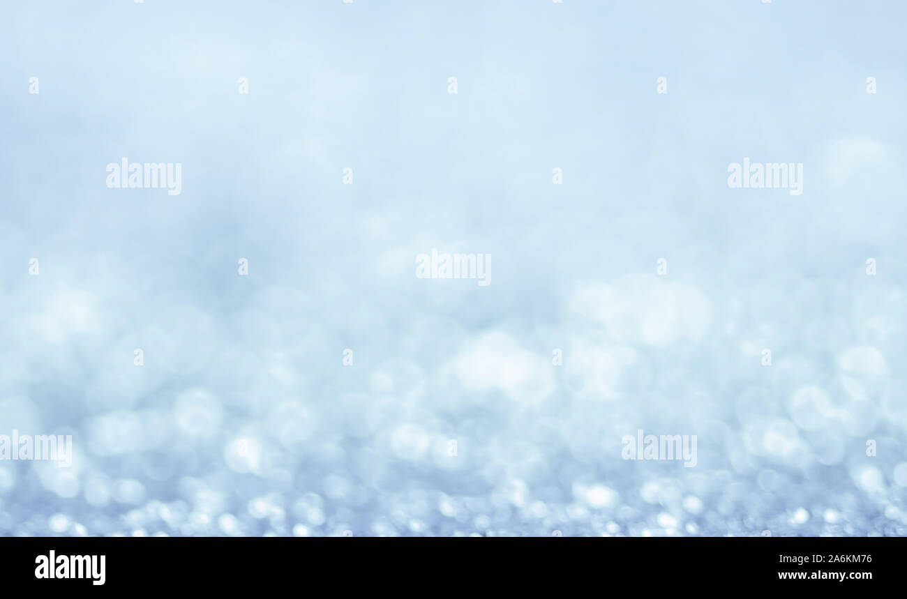 Abstract neve invernale natale luce blu con sfondo bokeh di fondo. Defocalizzata sparkle fiocchi di neve Foto Stock
