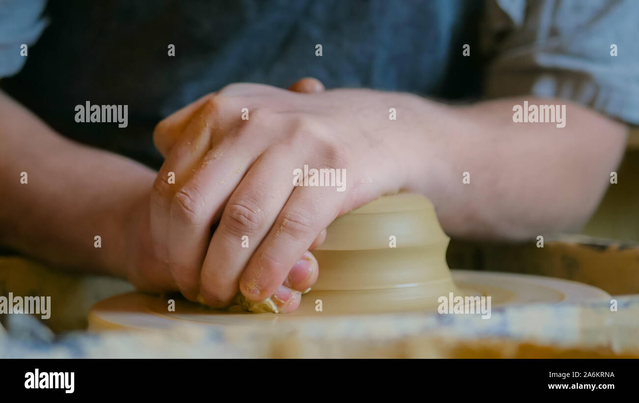 Professional potter maschio lavora con argilla sul tornio del vasaio Foto Stock