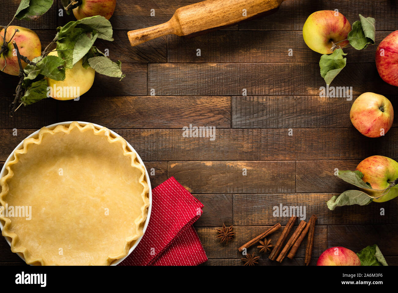 La torta di mele impasto su un tavolo di legno. Il processo di cottura, cibo sfondo, composizione del telaio con copia spazio. Tabella vista superiore Foto Stock
