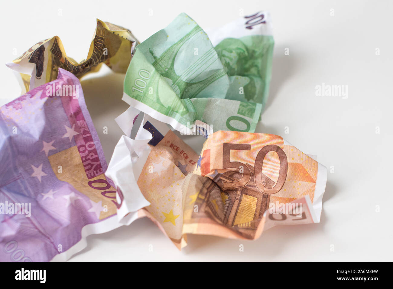 Crumpled euro denaro. Moneta europea le bollette di 50, 100, 200 e 500 euro su sfondo bianco. Messa a fuoco selettiva. Il valore monetario internazionale, forte Foto Stock