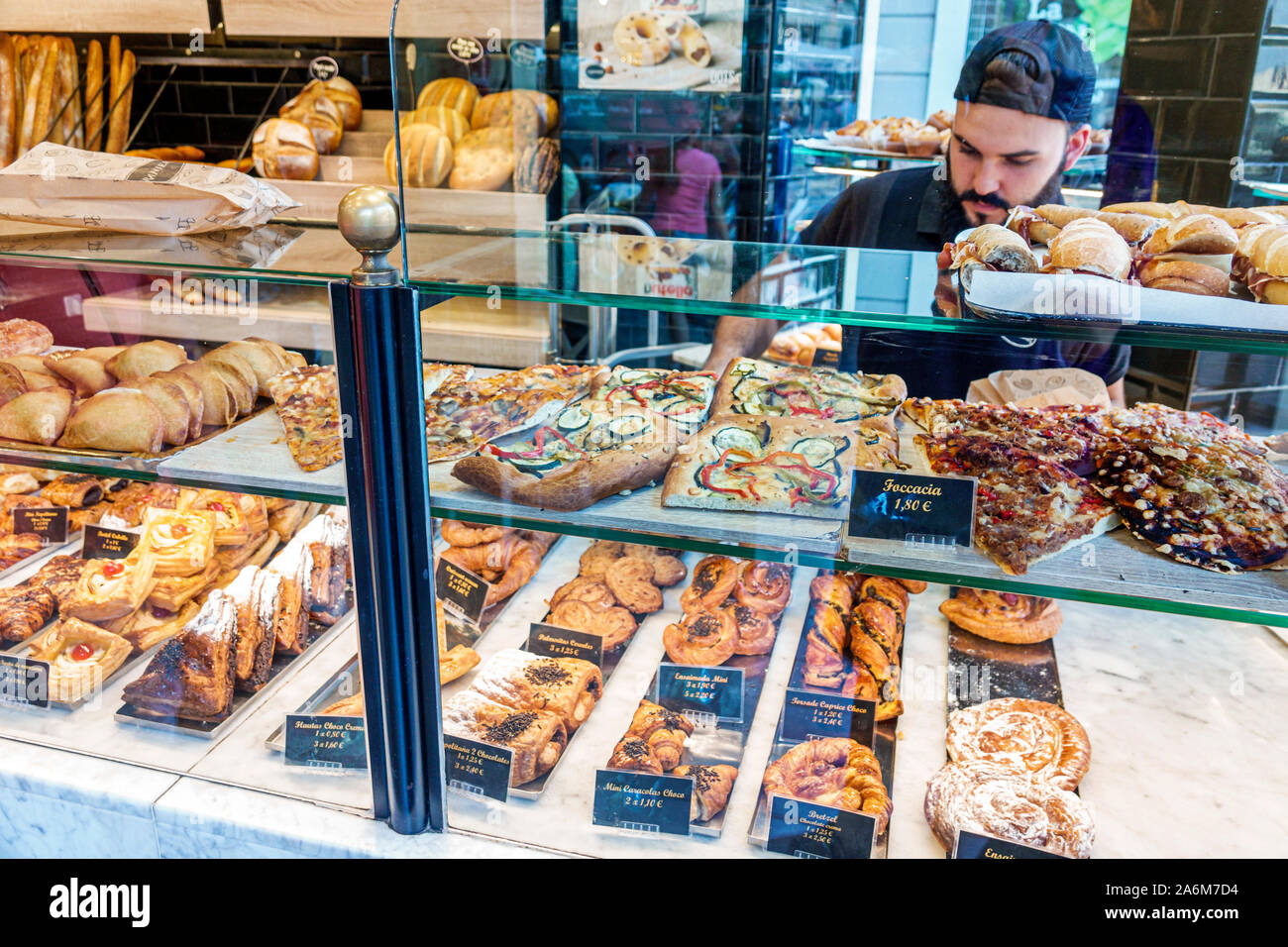 Valencia Spagna,Ciutat Vella,città vecchia,quartiere storico,Plaza Placa del Mercat,Granier,panetteria,cafe,interno,pasticceria,pizza,pane,uomo,bancone Foto Stock