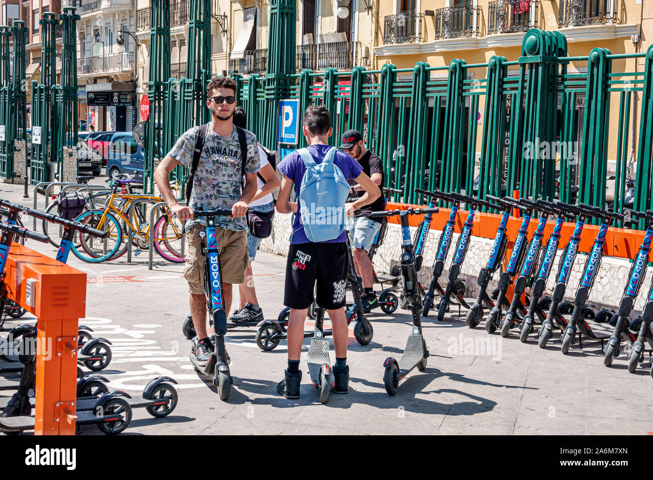 Valencia Spagna,stazione ferroviaria Renfe,servizio di condivisione scooter MOVO kick,noleggio docking station,uomo,ragazzo,teen,amici,trasporto verde,ES190831049 Foto Stock