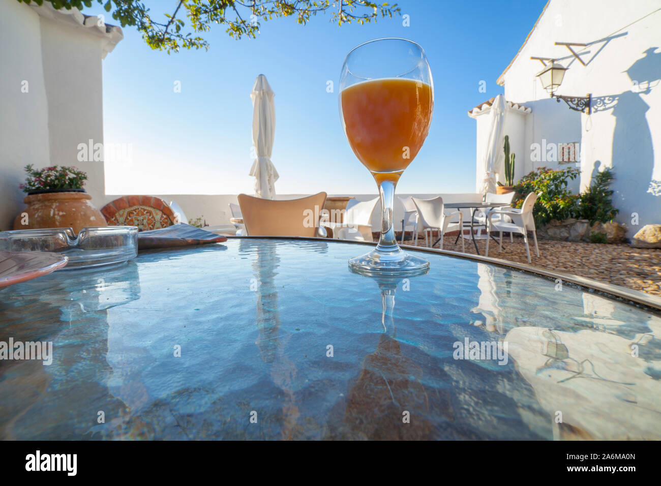 La prima colazione nel distretto di Axarquia. Comares, provincia di Malaga, Andalusia, Spagna. Vetro di succo d'arancia a Forefront Foto Stock