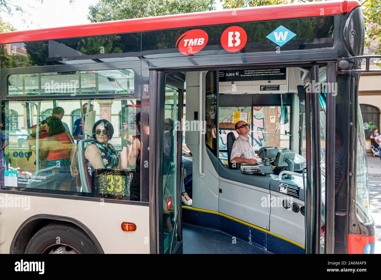Barcellona Spagna,Catalonia Sagrada Familia,bus,Transports Metropolitans de Barcelona,TMB,man,woman,driver,passeggero,fermo,porta aperta,ES190902048 Foto Stock