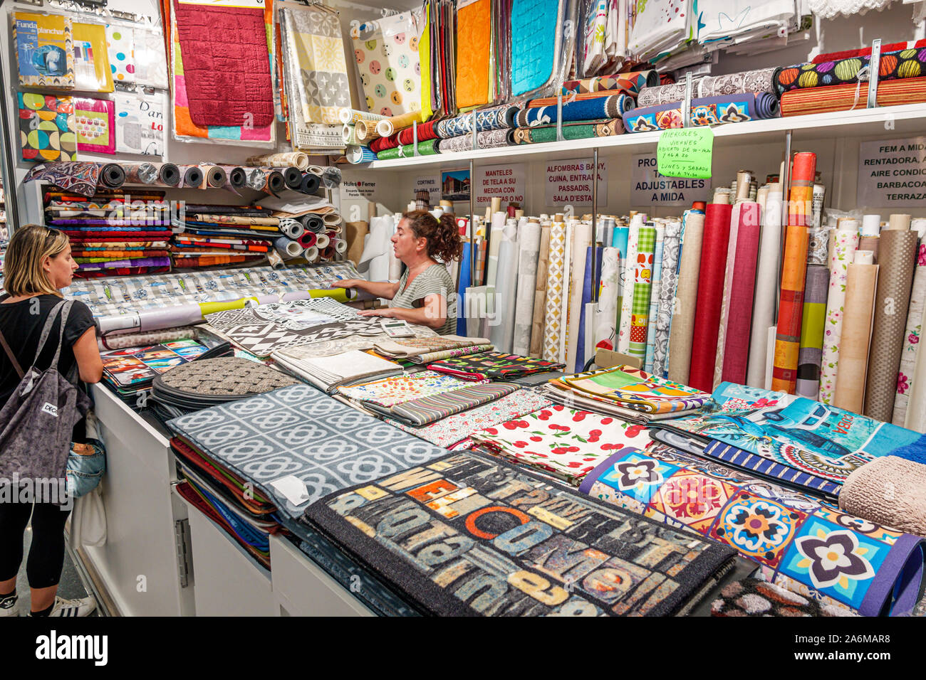 Barcellona Spagna,Catalonia Mercat de Sant Antoni Market,edificio storico,interno,vendita,vendita,stand vendita,vendita,bancarella,tessuti,tessuti,donna,shoppi Foto Stock