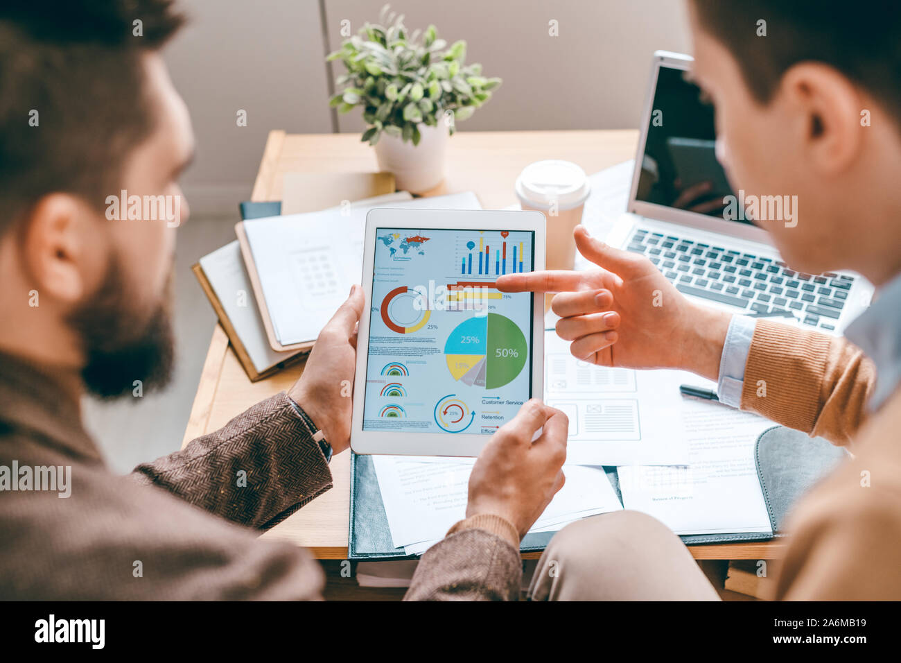 Uno dei giovani economisti contemporanea puntando al diagramma sul display del touchpad Foto Stock