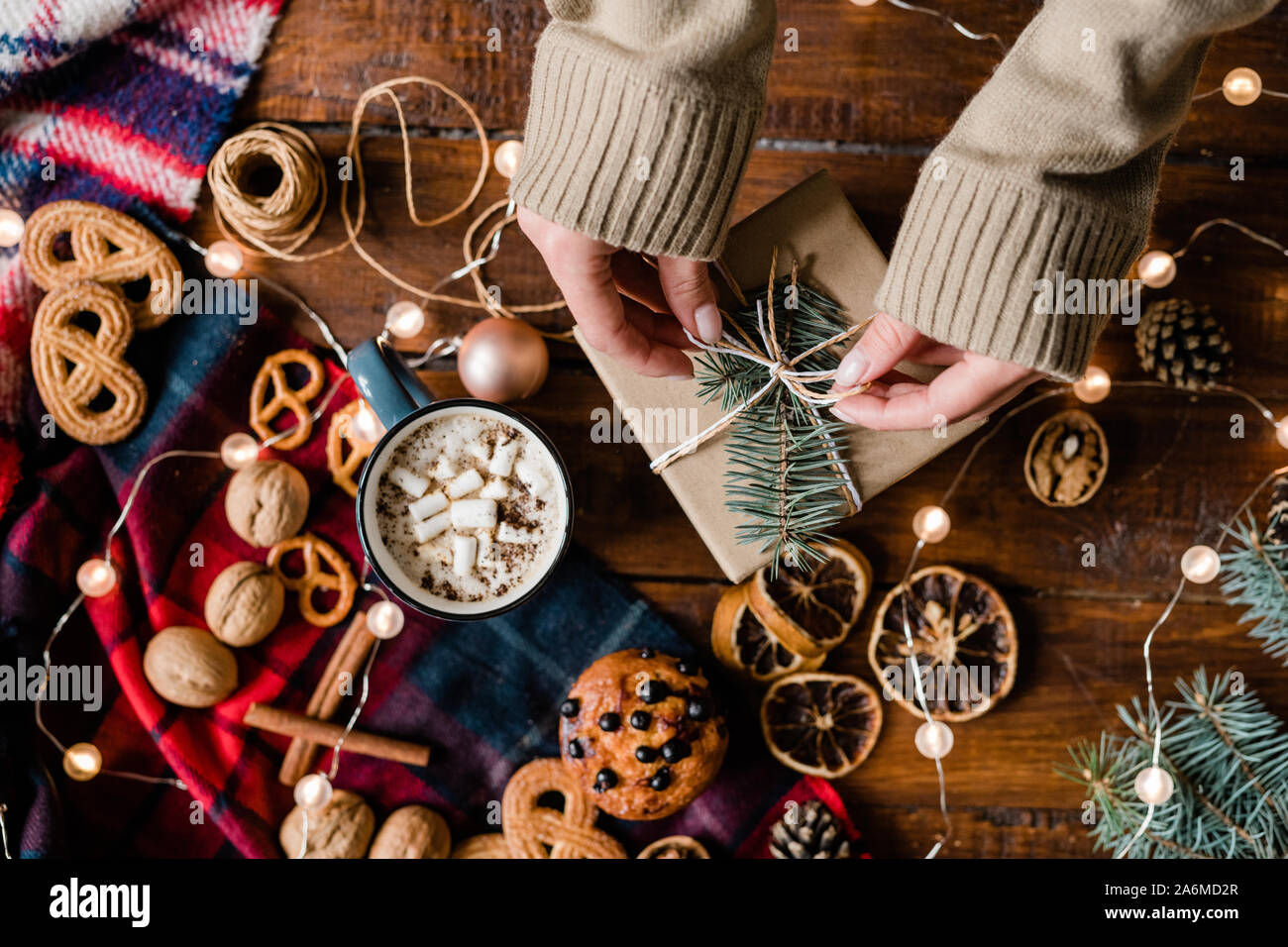 Vista delle mani del giovane donna da tavolo nodo sul top del giftbox Foto Stock