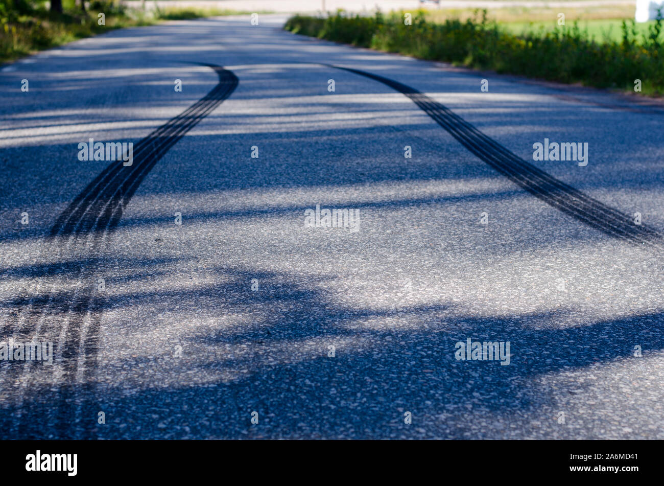 Skidmarks dopo una brusca frenata su una strada stretta con manto di asfalto. Foto Stock