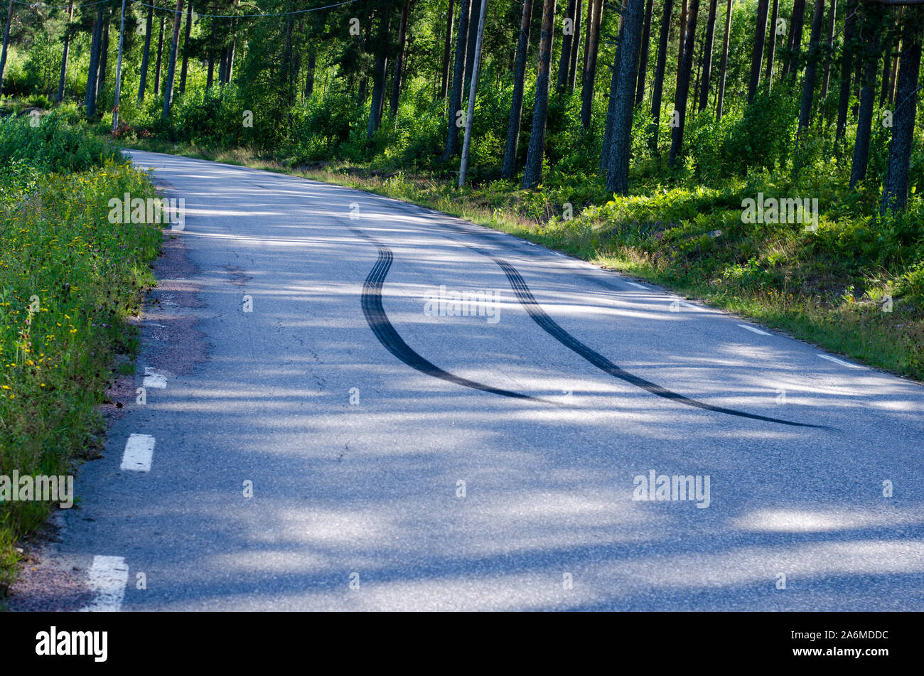 Skidmarks dopo una brusca frenata su una strada stretta con manto di asfalto. Foto Stock