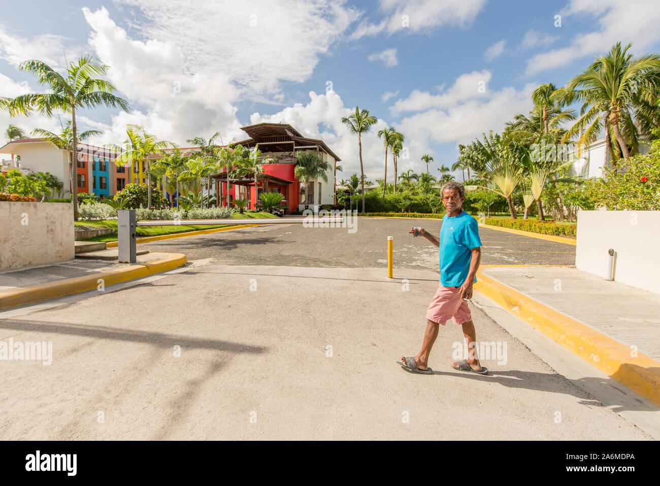 Punta Cana, Repubblica Dominicana; 12 aprile 2014: uomo attraversa la strada con in mano un bicchiere di caffè al mattino. Foto Stock