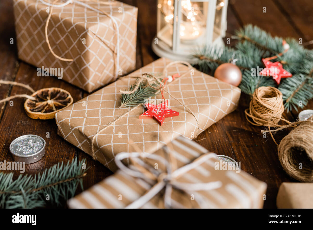Avvolto giftbox con delle conifere e la stella rossa di decorazione su top tra xmas stuff Foto Stock