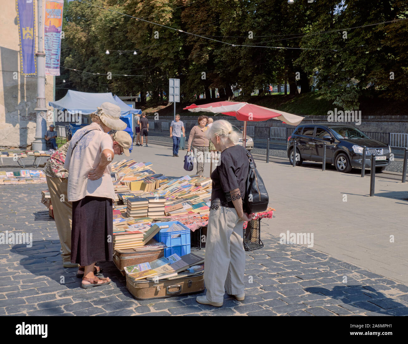 Persone navigando in un libro usato in stallo al mercato di Lviv in Ucraina. Foto Stock