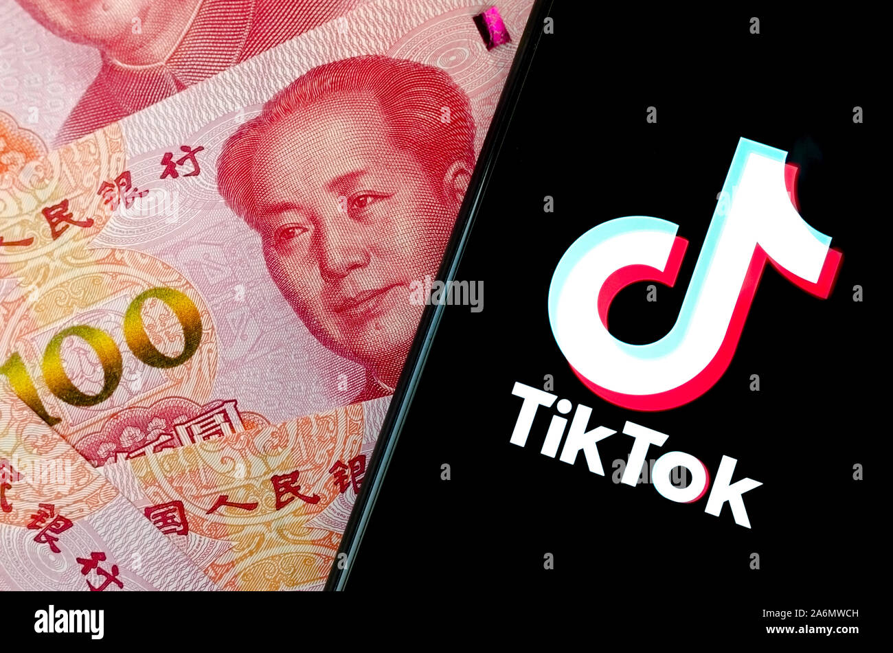 TikTok logo app sullo schermo dello smartphone e sfocata denaro cinese dietro. Foto Stock