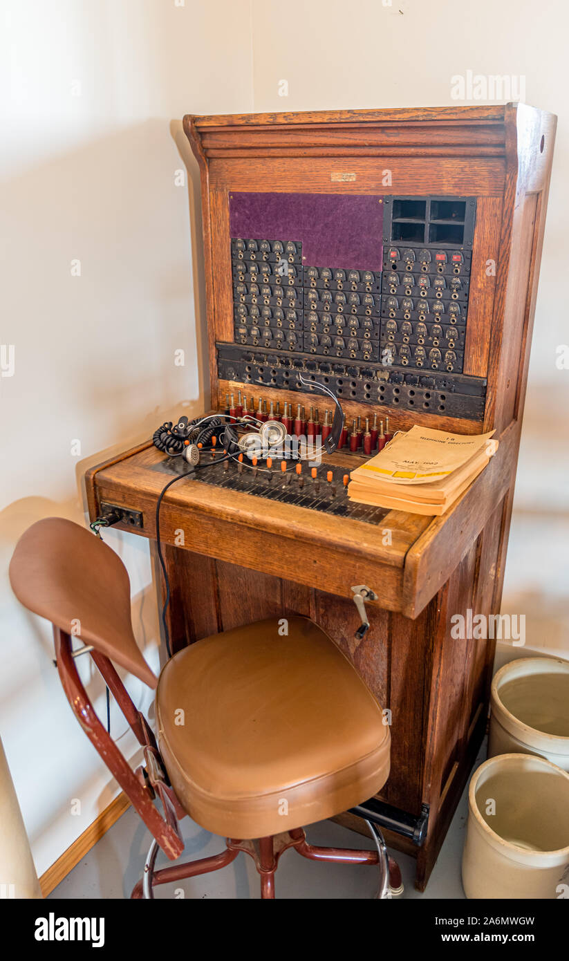 Antique centralino telefonico con sedia e elenco telefonico Foto Stock