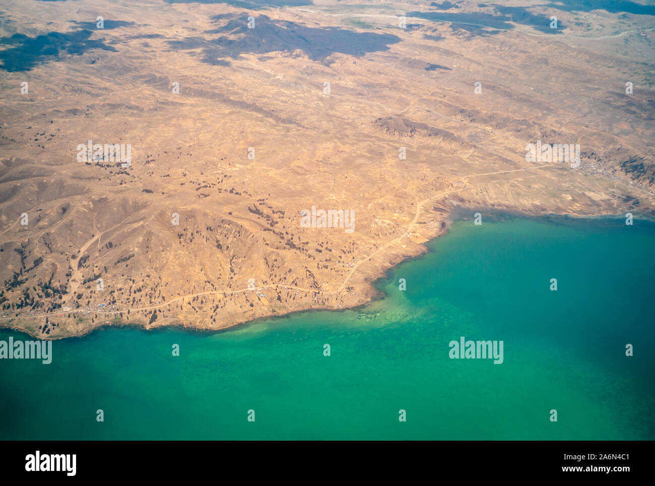 Vista aerea dell'ambiente desertico del Lago Titikaka e le piccole case intorno ad esso con le nuvole Foto Stock