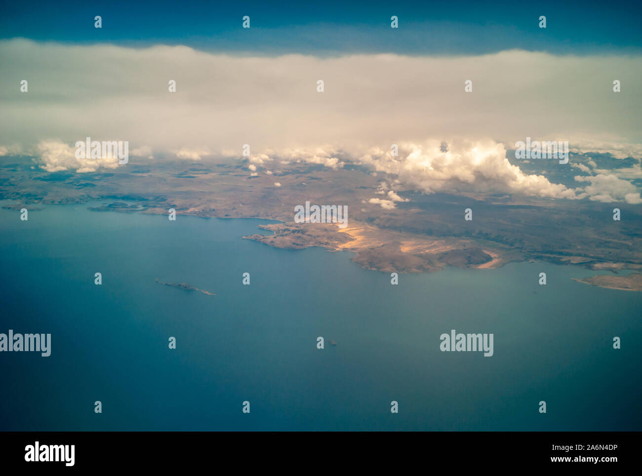 Vista aerea dell'ambiente desertico del Lago Titikaka e le piccole case intorno ad esso con le nuvole Foto Stock