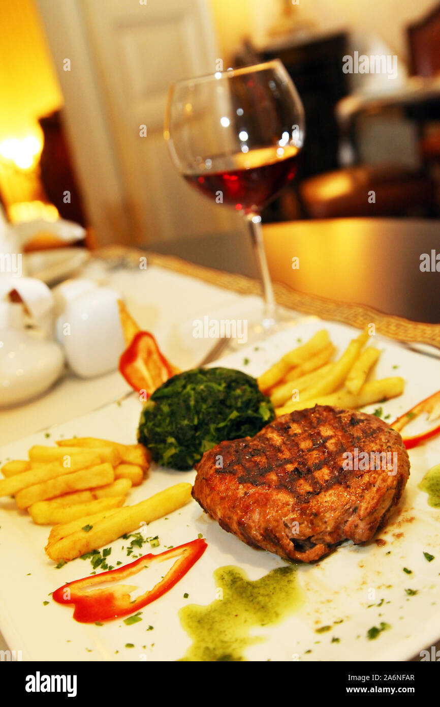 Polpette e verdure con vino rosso sul ristorante tabella Foto Stock