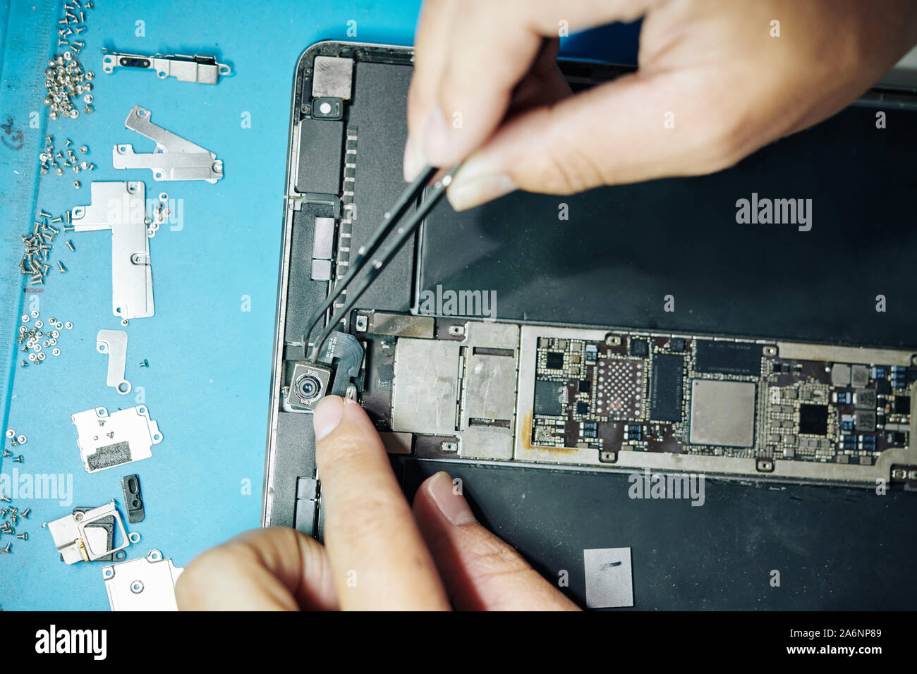 Le mani del lavoratore di fabbricazione che mostra il processo di creazione di fotocamera nel computer tablet Foto Stock