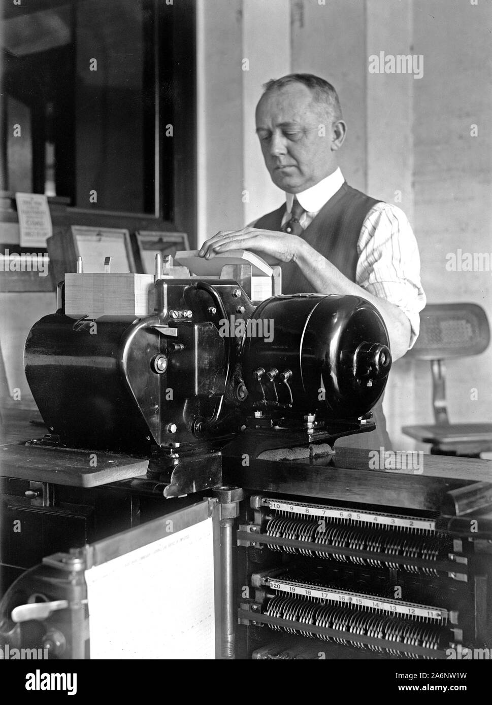 Uomo al lavoro tabulando macchina presso il Bureau ca. 1919 Foto Stock