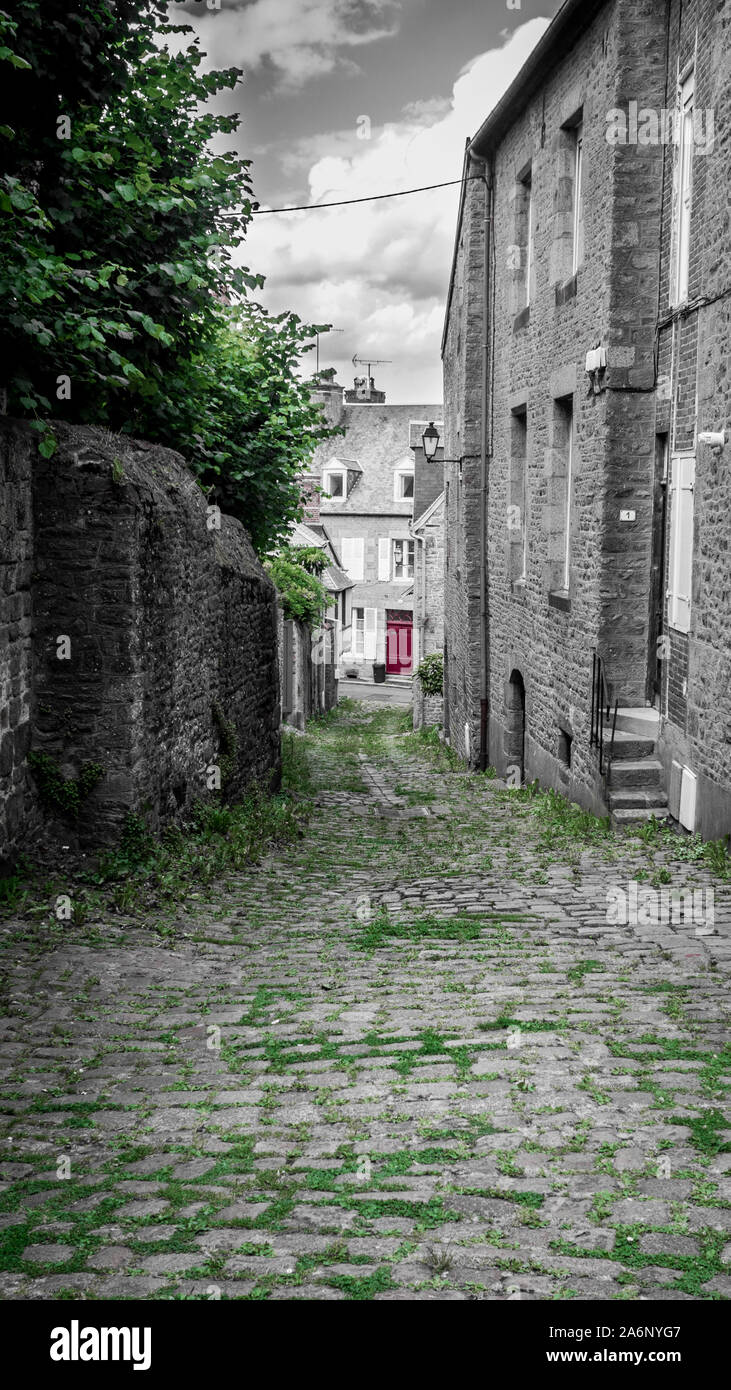 Vecchio villaggio stone road in Avanche village, Francia, parzialmente dissaturato foto con porta rossa e verde erba Foto Stock