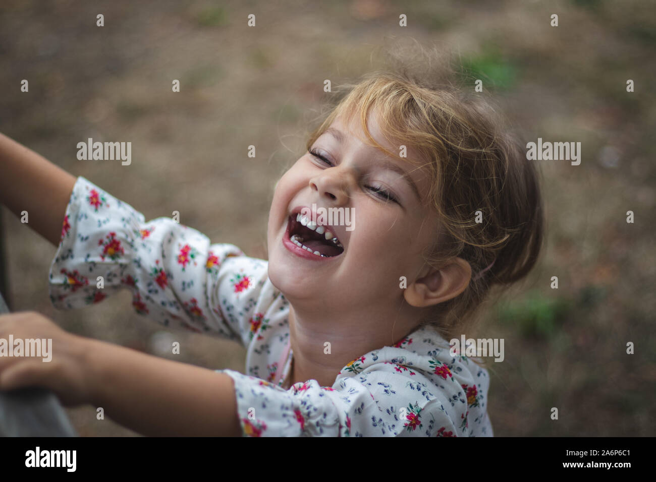 Carino bambina (4-5 anni) a ridere e divertirsi. Bambina piangere dalle risate Foto Stock