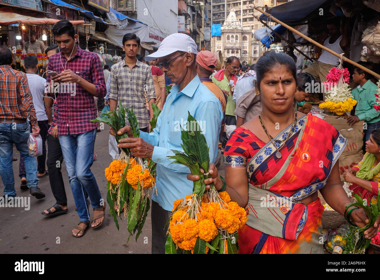 Rivenditori di calendula fiori vicino Phul Galli (Fiore Lane) nelle affollate Bhuleshwar area mercato, Kalbadevi, Mumbai, India Foto Stock