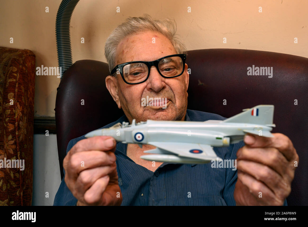 89-anno vecchio tenendo una plastica Airfix aereo modello Foto Stock