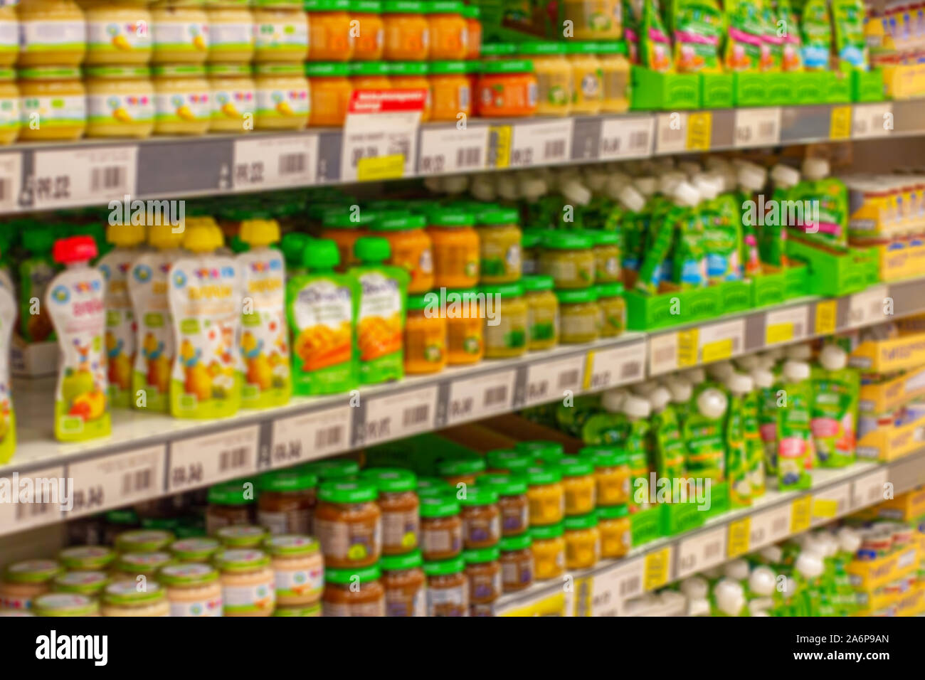 Sfondo sfocato, cibo per neonati scaffali del supermercato, purea di frutta e la crema di farina e di latte per l'alimentazione di bambini piccoli, borse e scatole di cibo per neonati Foto Stock