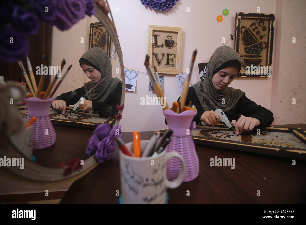 (191028) -- GAZA, 28 ottobre 2019 (Xinhua) -- artista Palestinese Hala Abu Qaoud fa arte pezzi utilizzando chicchi di caffè a casa sua nel sud della striscia di Gaza città di Rafah, 28 ottobre 2019. Abu Qaoud, 20, studi belle arti presso una università locale nella Striscia di Gaza. Lei vende la sua arte pezzi su le piattaforme di social media. (Foto di Khaled Omar/Xinhua) Foto Stock