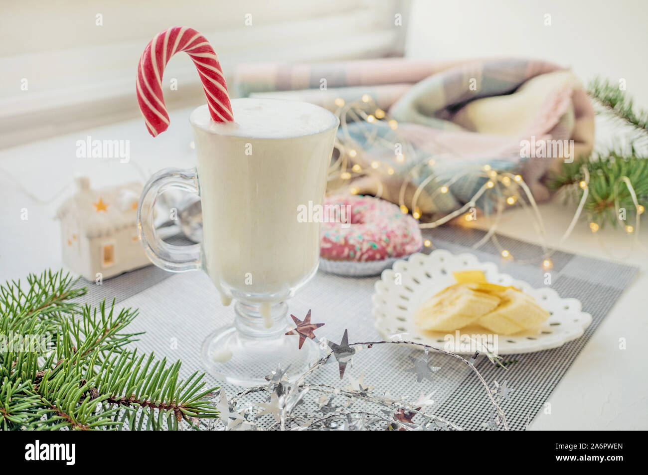 Tradizionale irlandese inverno crema zabaione cocktail in una tazza di vetro con il latte, il rum e la cannella, banana ricoperta con panna montata, le decorazioni di Natale. N Foto Stock