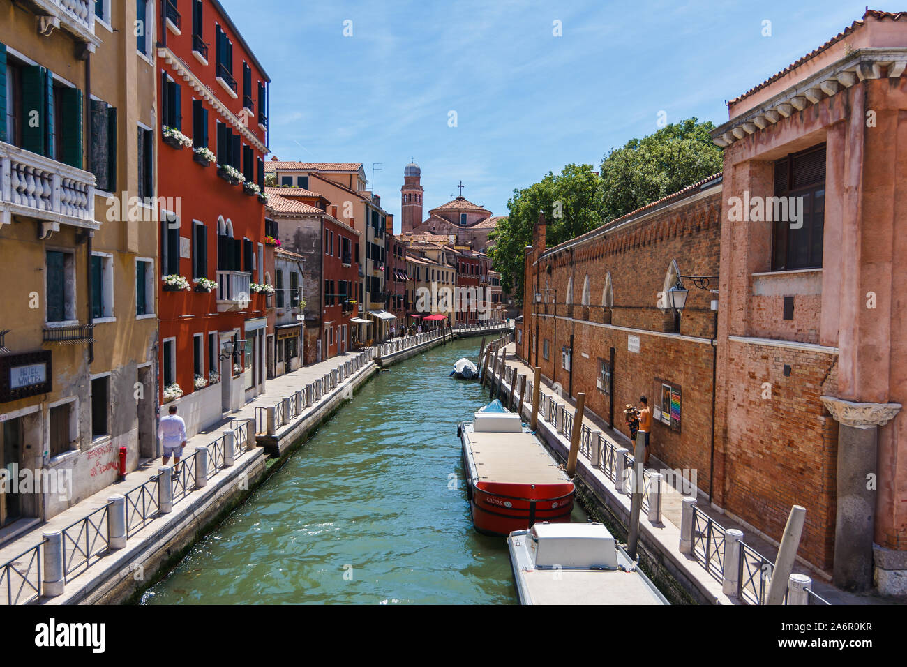 Canal Grande di Venezia con barche e gandules docket imbarcazione a motore vicino al ponte. Coloratissima casa residenziale e piccoli ponti attraversano il Canal. Foto Stock