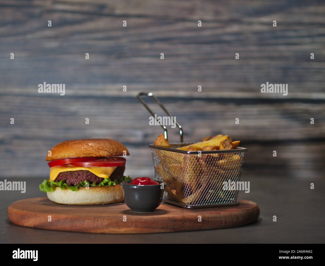 Vegan impianto basato hamburger con patatine fritte e ketchup servita su rustiche vassoio in legno Foto Stock